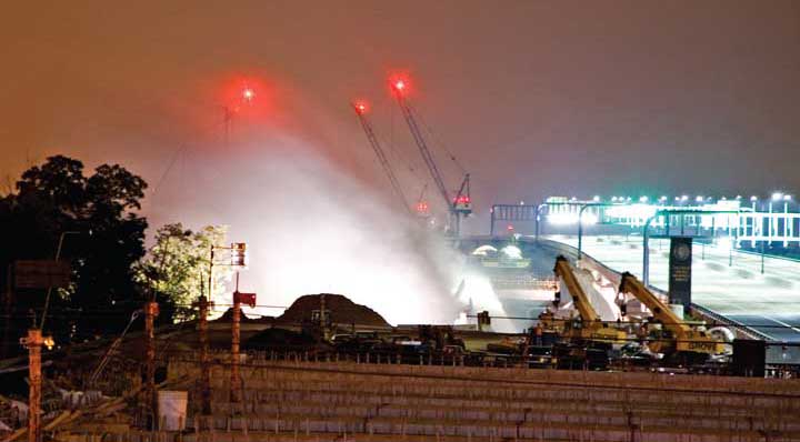 For almost 45 years, the old Woodrow Wilson Bridge carried the Capital Beltway across the Potomac River between Maryland and Alexandria, Virginia. In under a second, using the tools of physics, chemistry and civil engineering, a significant portion of the bridge in Alexandria disappeared with a series of flashes, a bang and a cloud of dust. The demolition occurred in the wee hours of August 29, while traffic on the new Woodrow Wilson Bridge (visible at right) was shut down to avoid potential mishap. Despite the late hour, a crowd of several thousand witnessed the blast; included among them was intrepid APS News photographer Ken Cole.