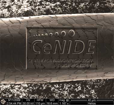 A human hair into which the logo of the Center for Nanointegration Duisburg-Essen (CeNIDE) was engraved using a focused ion beam (FIB). 