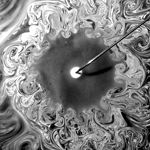 An oil-in-water emulsion spreads on the surface of pure water